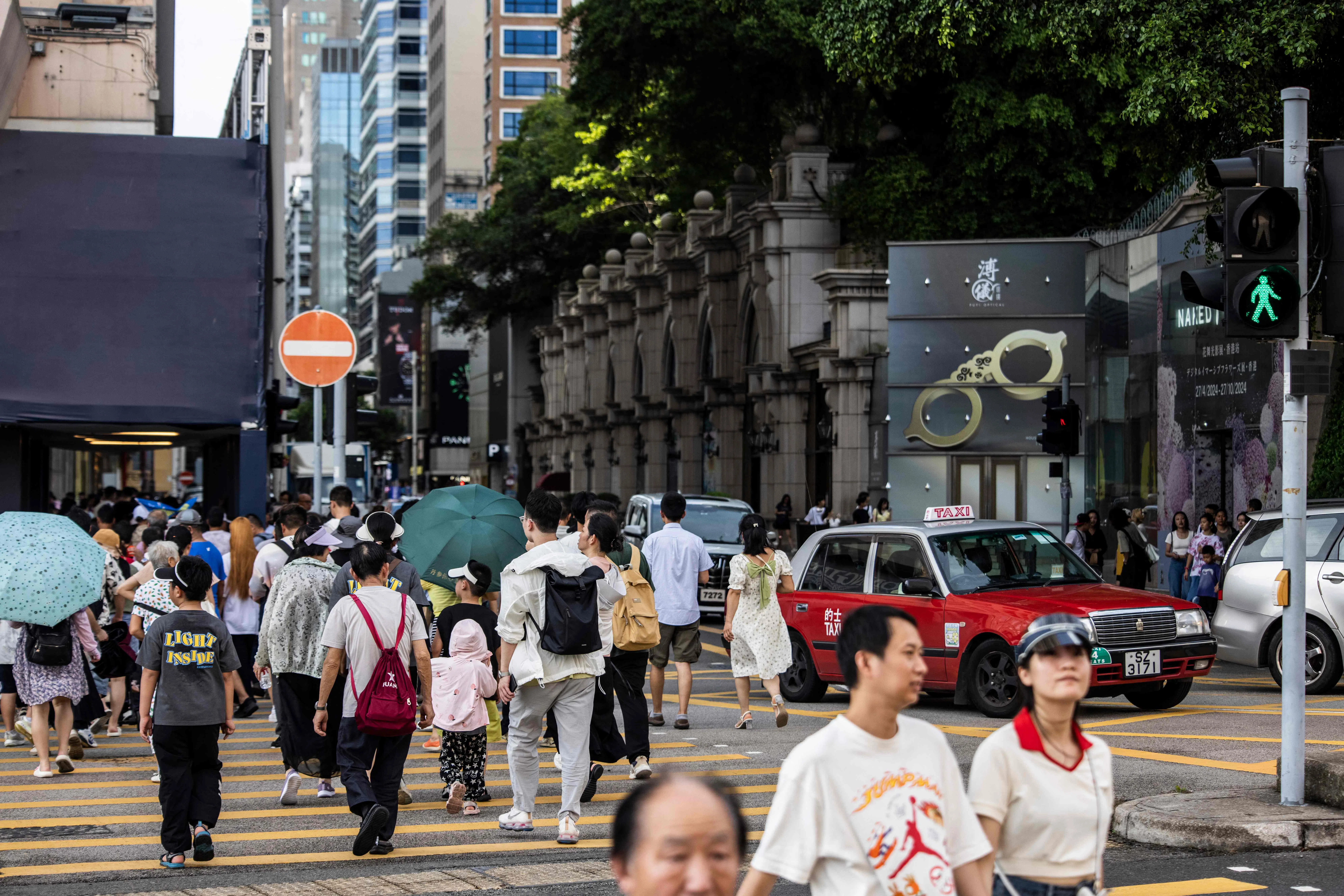 A taxi drives along a road at the Tsim Sha Tui district of Hong Kong on 11 July 2024. (Isaac Lawrence/AFP)