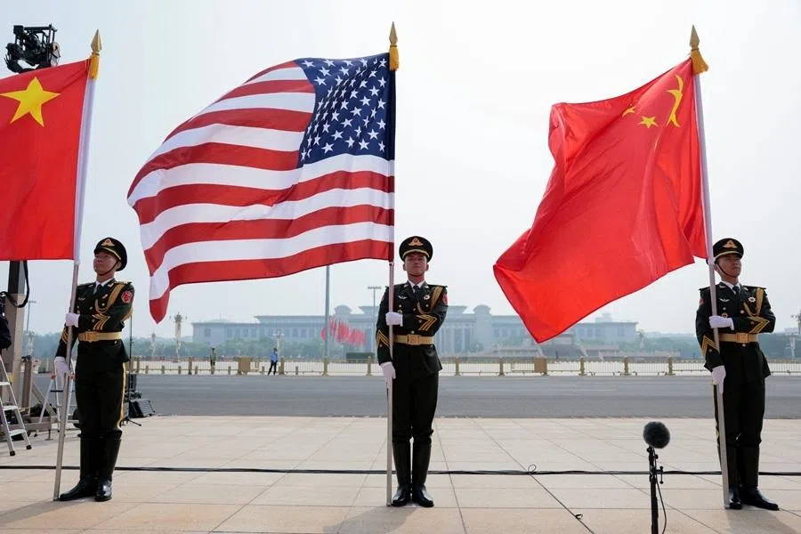 People's Liberation Army (PLA) members hold up a US flag and Chinese flags ahead of the arrival of US President Donald Trump for a welcome ceremony at the Great Hall of the People in Beijing, China, on 14 May 2026.
