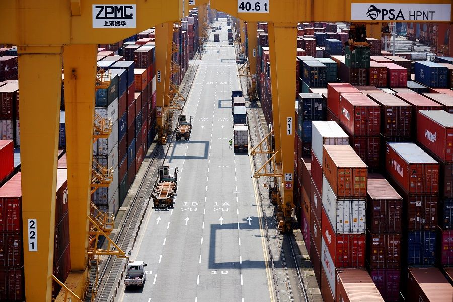 A truck driver stands next to his truck as he gets ready to transport a shipping container at Pusan Newport Terminal in Busan, South Korea, 1 July 2021. (Kim Hong-Ji/File Photo/Reuters)