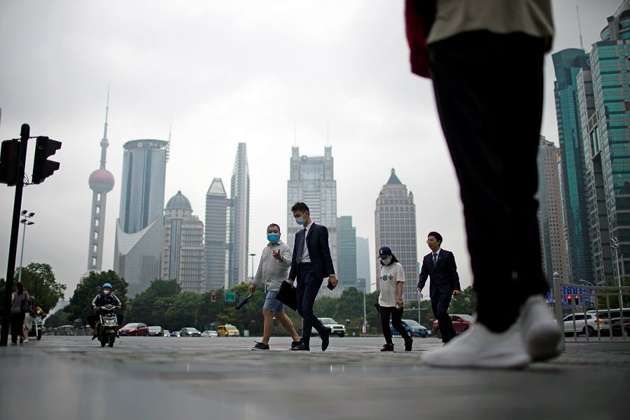People walk along at financial district of Lujiazui in Shanghai, China, 15 October 2021. (Aly Song/Reuters)