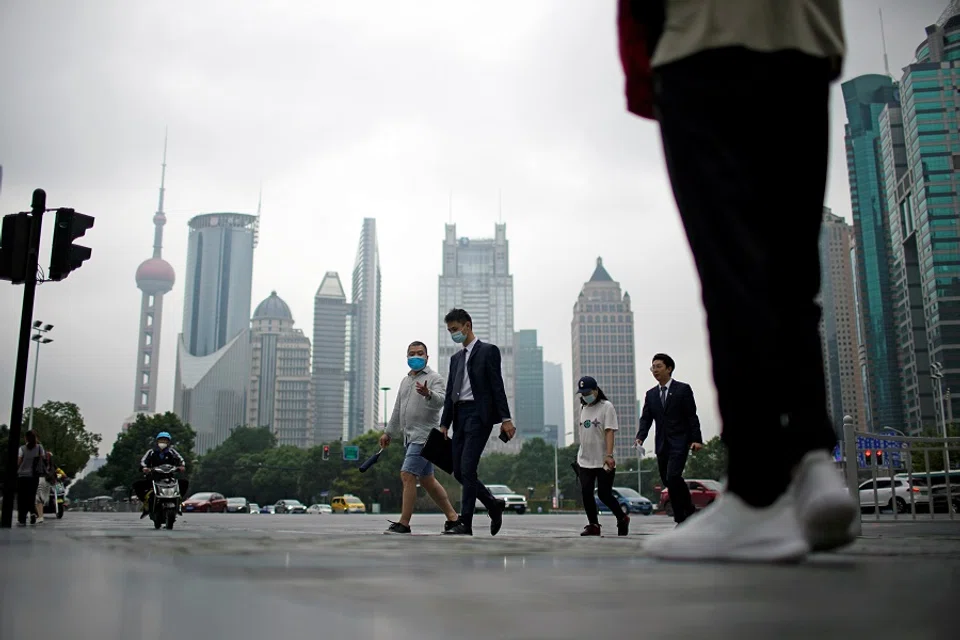 People walk along at financial district of Lujiazui in Shanghai, China, 15 October 2021. (Aly Song/Reuters)