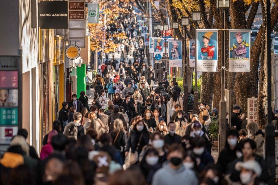 People walk through a shopping street in Omotesando area of Tokyo on 15 December 2022. (Yuichi Yamazaki/AFP)