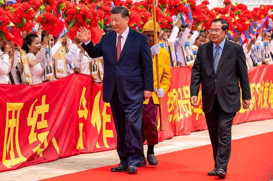 This pool photo taken and released on 18 April 2025 by Agence Kampuchea Presse shows China’s President Xi Jinping (C) greeting people while walking with Cambodia’s Senate President Hun Sen (R) upon his departure at Phnom Penh International Airport. (AFP)