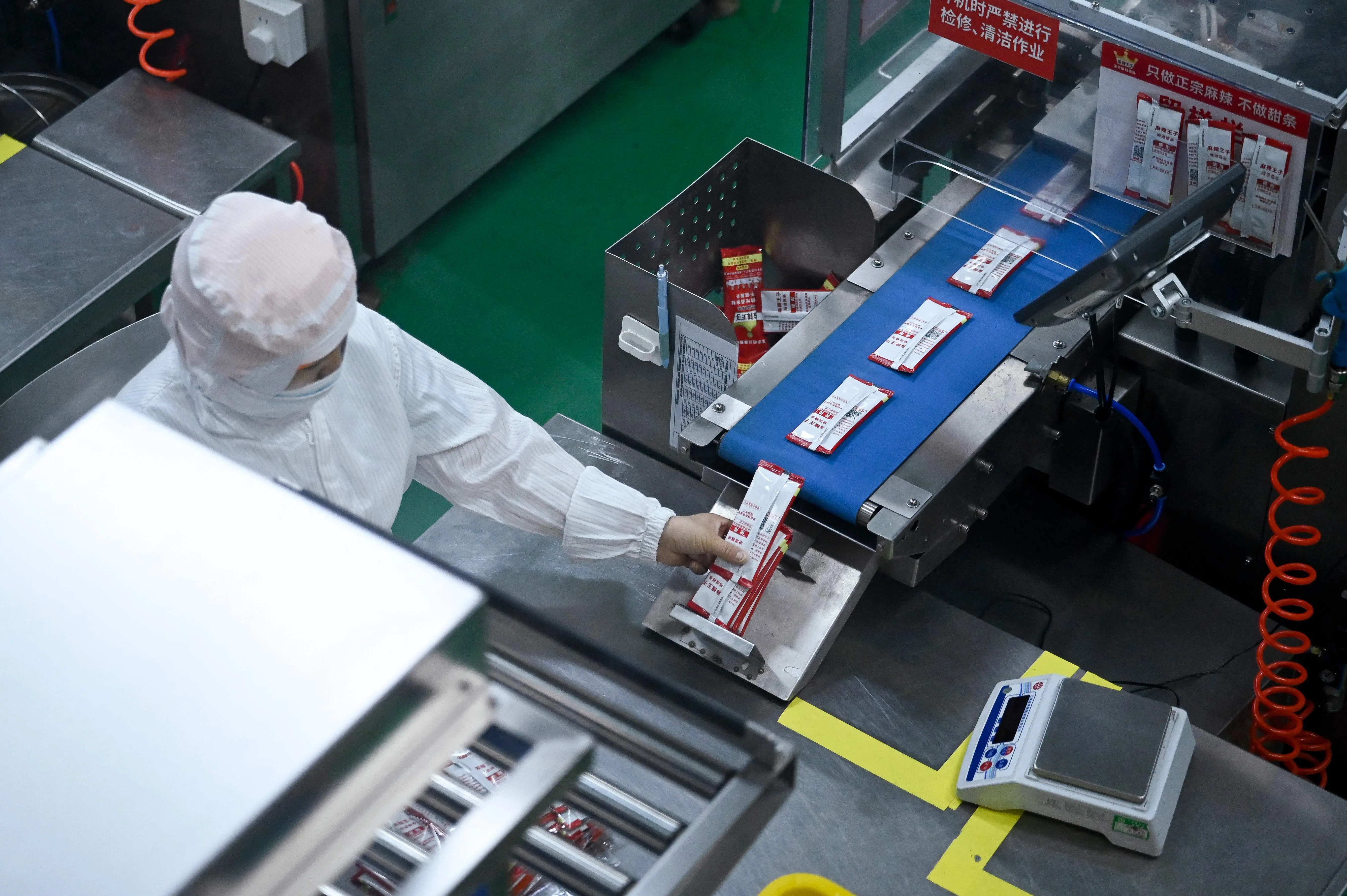 This picture taken on 17 June 2026 shows a worker packaging spicy strips at a factory in Pingjiang county, Hunan province, China.