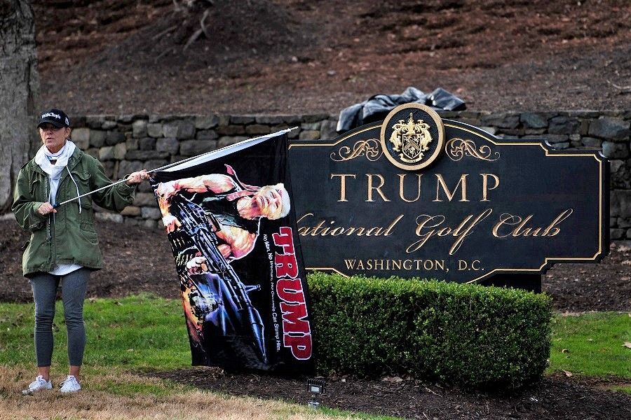 A supporter of US President Donald Trump waits outside the Trump National Golf Club as the president plays golf, 13 December 2020, in Sterling, Virginia. (Brendan Smialowski/AFP)