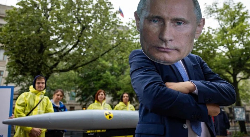 An activist wearing a mask of Russia's President Vladimir Putin stands next to fellow activists of the IPPNW (International Physicians for the Prevention of Nuclear War) peace organisation posing behind a mockup of a nuclear bomb as they demonstrate for the abolition of nuclear weapons in front of the Russian embassy in Berlin on 23 June 2023. (Odd Andersen/AFP)