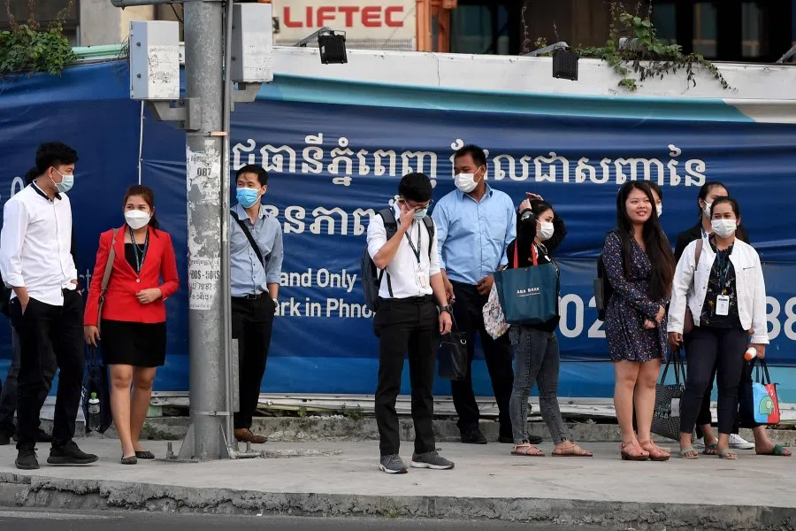 People wait at a traffic light on a street in Phnom Penh on 11 January 2021. (Tang Chhin Sothy/AFP)