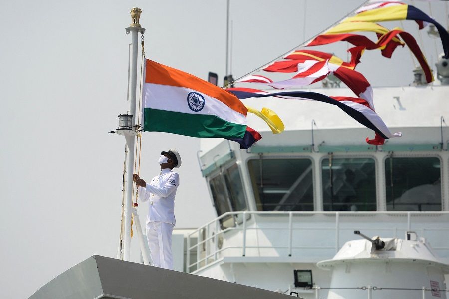 A coast guard official raises the Indian national flag on board the Indian Coast Guard offshore patrol vessel "Vajra" during its commissioning ceremony, in Chennai, India, on 24 March 2021. (Arun Sankar/AFP)