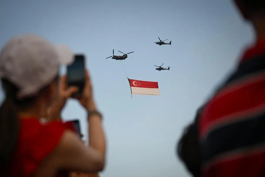 People watch the iconic state flag flypast during Singapore’s National Day Parade on 9 August 2025.
