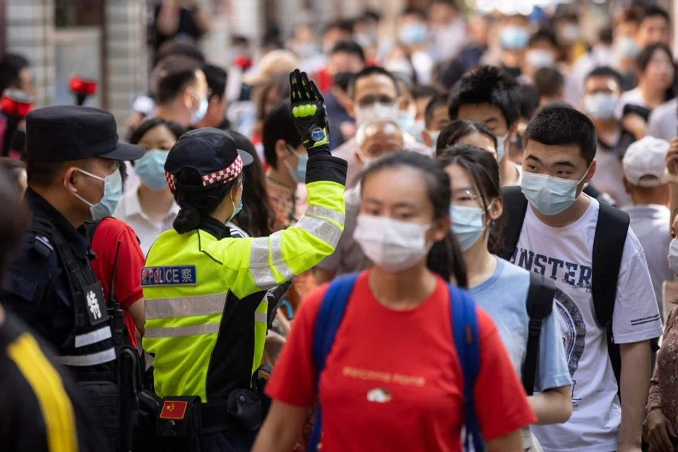 Students arrive at a school to take the National College Entrance Examination known as 'gaokao' in Wuhan, Hubei province on 7 June 2021. (STR/AFP)