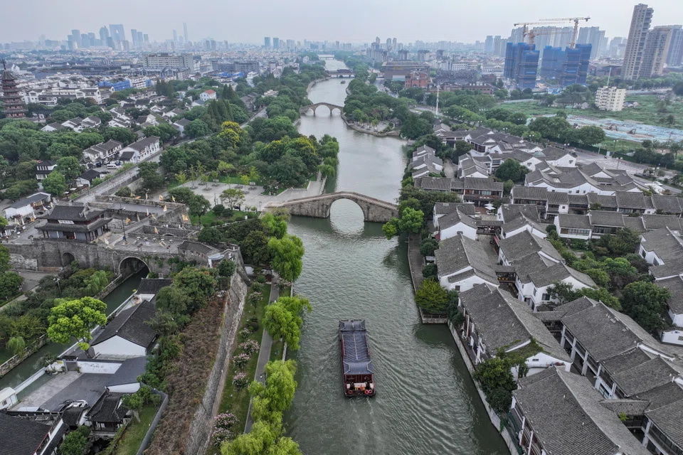 A drone camera captures a shot of an ancient canal with the Pan Gate seen to the side, in Suzhou, Jiangsu on 10 September.