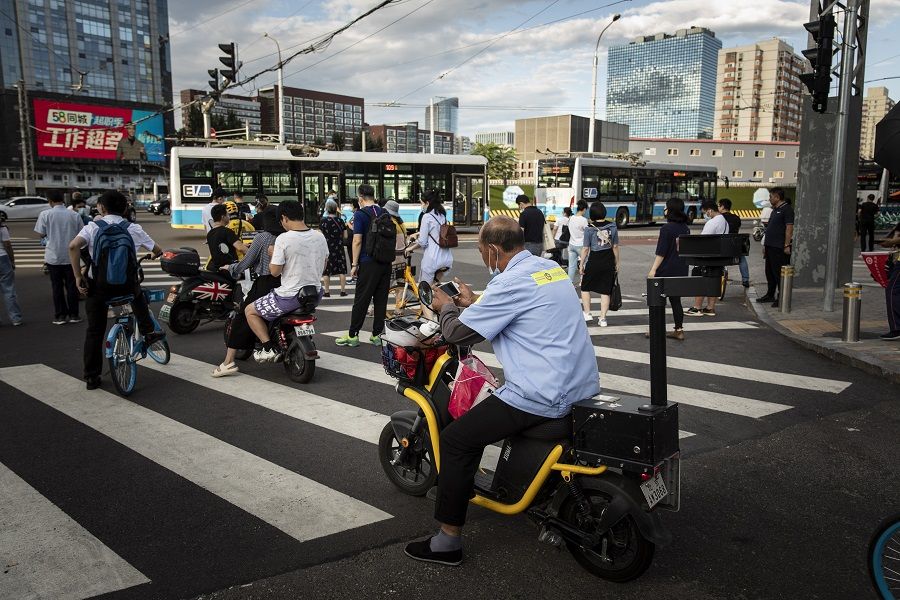 Commuters wait at a traffic intersection in Beijing, China on 25 August 2021. (Qilai Shen/Bloomberg)