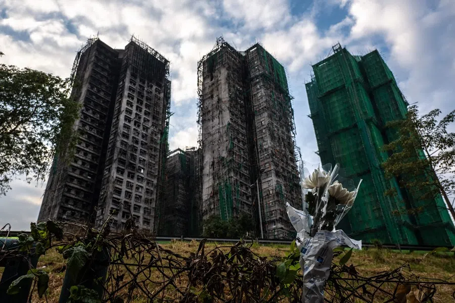 Flowers are seen in front of the Wang Fuk Court apartment blocks in the aftermath of the deadly 26 November fire in Hong Kong's Tai Po district on 3 December 2025.