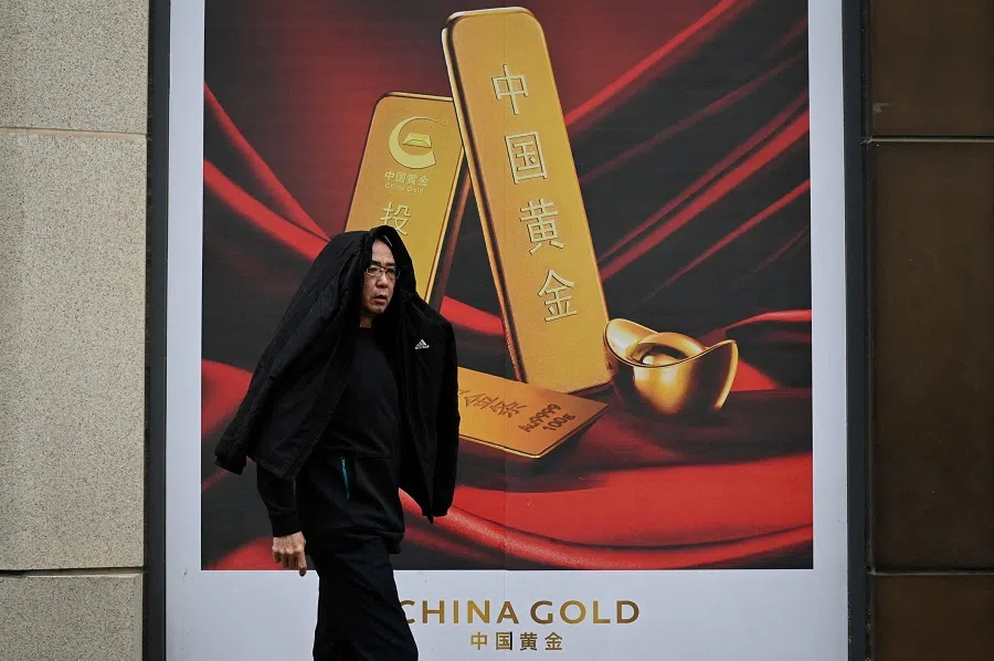 A man walks past a gold advertisement in Beijing, China, on 10 April 2024.