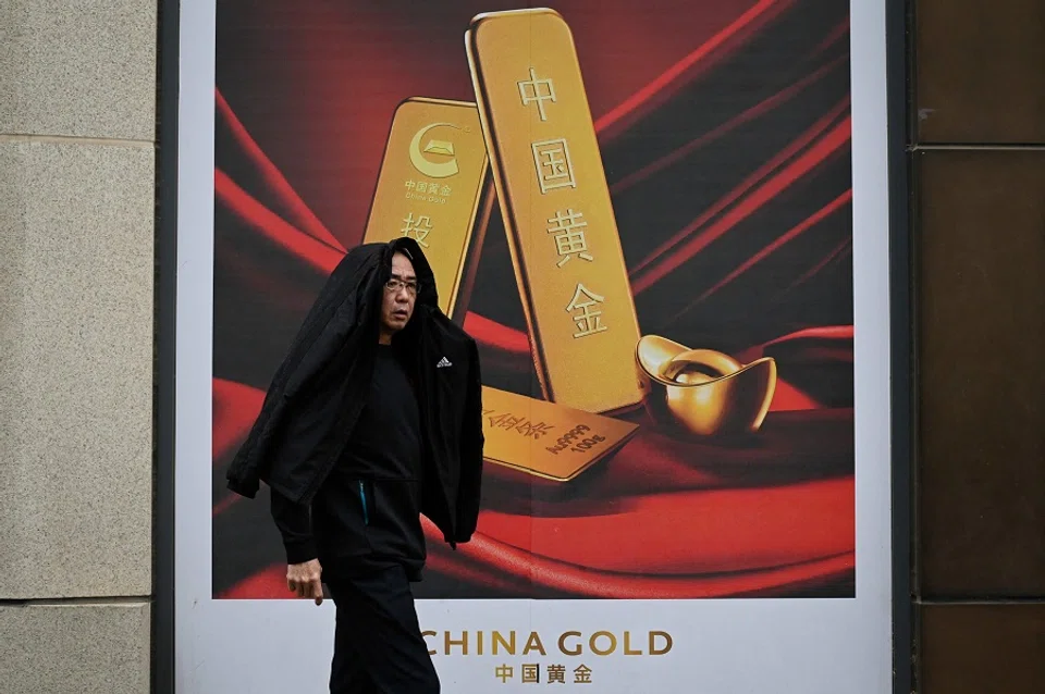 A man walks past a gold advertisement in Beijing, China, on 10 April 2024. (Wang Zhao/AFP)