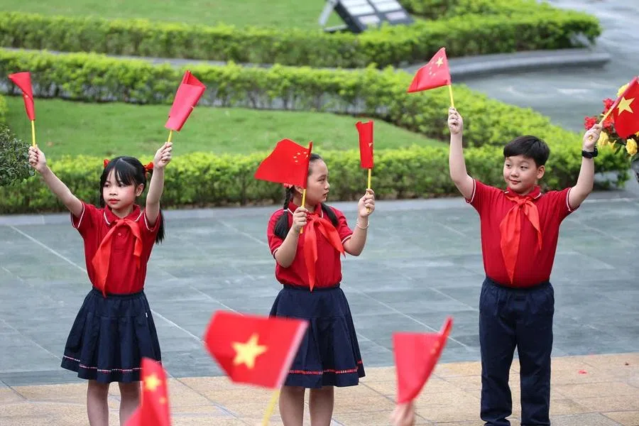 Children wave the flags of Vietnam and China ahead a welcome ceremony at the Presidential Palace in Hanoi, Vietnam, on 14 April 2025. (Luong Thai Linh/Reuters)