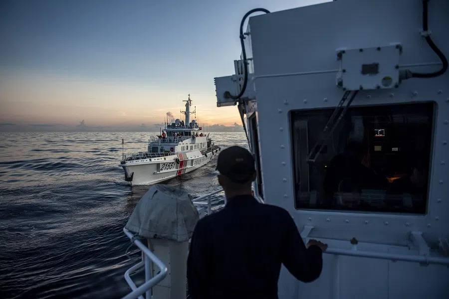 A Philippine Coast Guard personnel looks out at a China Coast Guard ship during a resupply mission for the BRP Sierra Madre, in the Second Thomas Shoal in the disputed South China Sea, on 10 November 2023. (Lisa Marie David/Bloomberg)