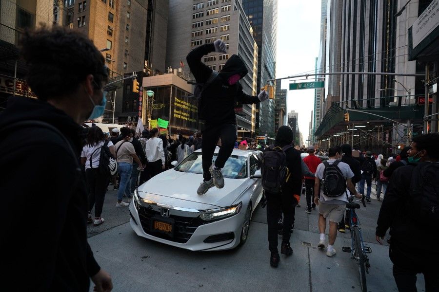 A protester jumps on a car in midtown during demonstrations over the death of George Floyd by a Minneapolis police officer on June 1, 2020 in New York. (Bryan R. Smith/AFP)