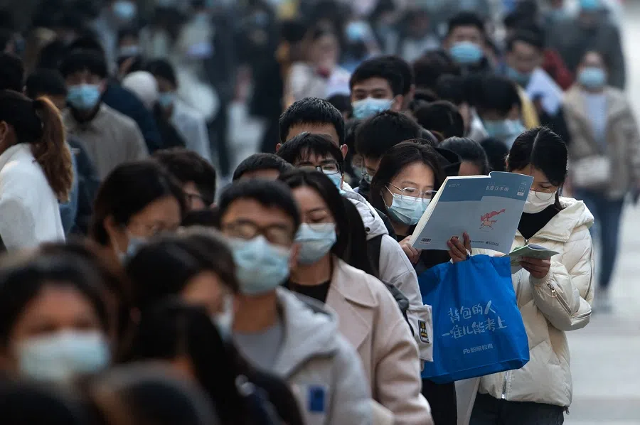 This photo taken on 28 November 2021 shows candidates queueing to take the national examination for admissions to the civil service in Wuhan, Hubei province, China. (AFP)