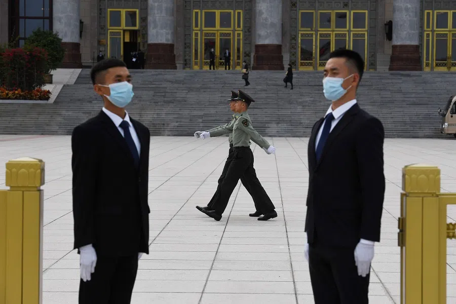 Chinese soldiers march past security guards before a reception at the Great Hall of the People on 30 September 2020. (Greg Baker/AFP)