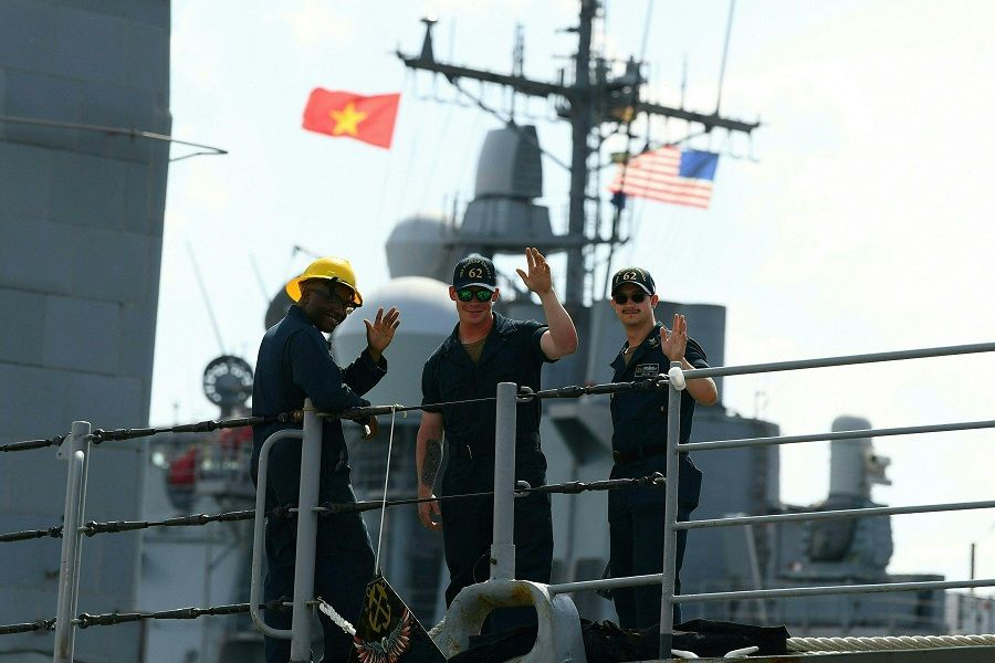 Sailors gesture on the USS Robert Smalls guided missile cruiser, which is part of the carrier group accompanying the US Navy's USS Ronald Reagan aircraft carrier, at Tien Sa Port in Danang, Vietnam, on 25 June 2023. (Nhac Nguyen/AFP)