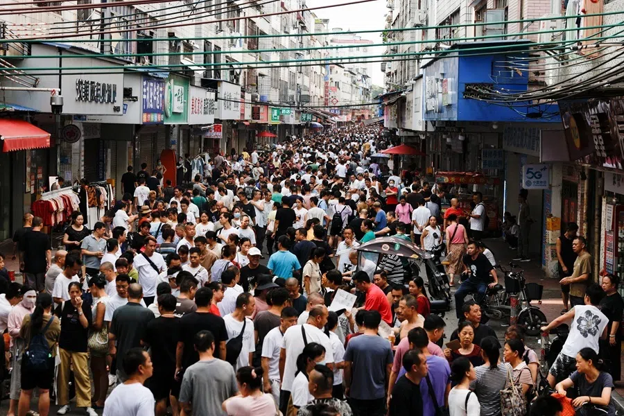 Job seekers and recruiters for garment factories gather on a street in Haizhu District, Guangzhou, Guangdong province, China, 28 July 2026.
