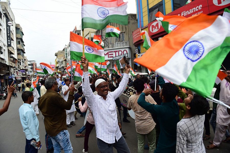 People cheer and wave Indian national flags during a march to celebrate the country's upcoming 75th Independence Day celebrations in Ahmedabad, India, on 12 August 2022. (Sam Panthaky/AFP)