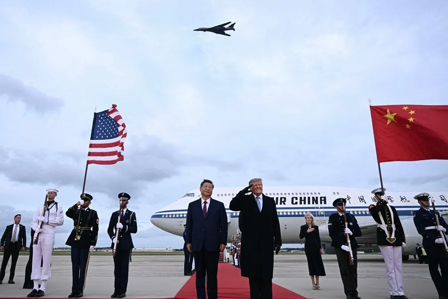 US President Donald Trump reacts after a B1 bomber flew past during the national anthems while he greeted Chinese President Xi Jinping upon his arrival at Joint Base Andrews in Maryland, 23 September 2026.