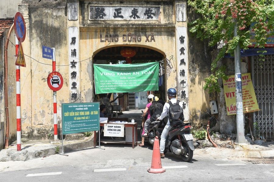 People on motorbikes drive into a quarantine area amid the coronavirus disease (Covid-19) in Hanoi, Vietnam, 6 September 2021. (Stringer/Reuters)