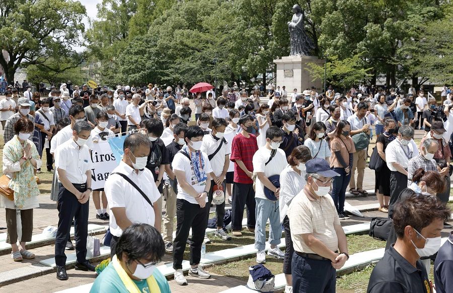 People offer silent prayers for the victims of the 1945 atomic bombing, during a ceremony commemorating the 75th anniversary of the bombing at Atomic Bomb Hypocenter Park in Nagasaki, Japan in this photo taken by Kyodo, 9 August 2020. (Kyodo via Reuters)
