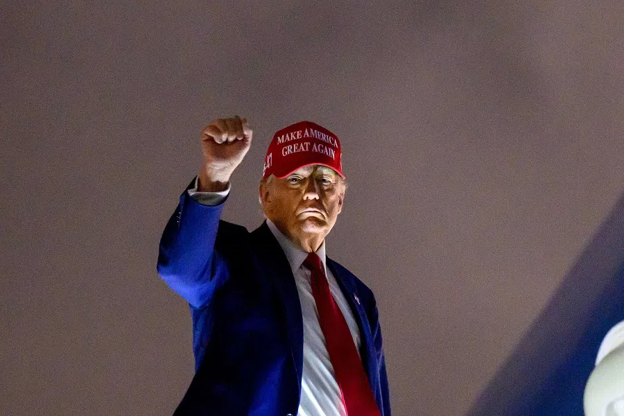 US President Donald Trump pumps his fist as he boards Air Force One before departing Miami International Airport, in Miami, Florida on 3 April 2025. (Mandel Ngan/AFP)