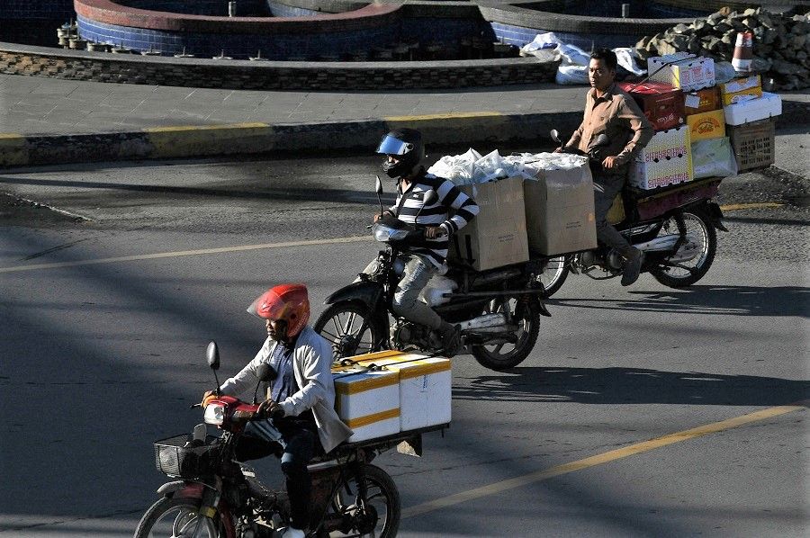 People transport goods on their motorcycles in Phnom Penh, Cambodia, on 9 September 2022. (Tang Chhin Sothy/AFP)