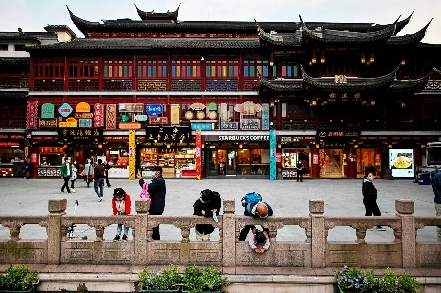 People wearing face masks as a preventive measure against the Covid-19 coronavirus visit the Yu Garden in Shanghai on 23 March 2020. (Hector Retamal/AFP)