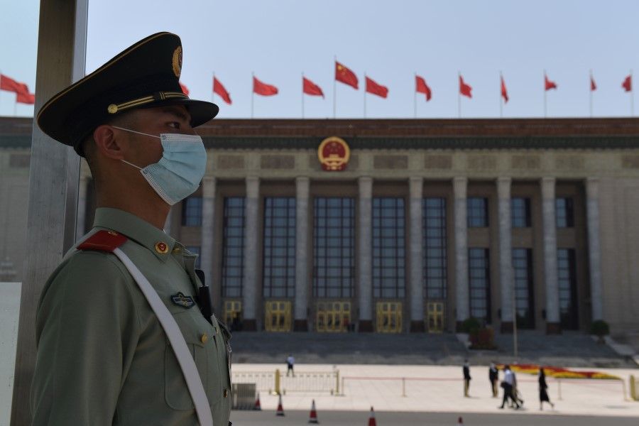 A paramilitary policeman stands guard outside the Great Hall of the People ahead of the closing session of the National People's Congress in Beijing, 28 May 2020. (Nicolas Asfouri/AFP)