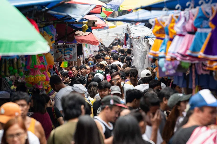 People crowd a street on Christmas eve in Manila on 24 December 2024.
