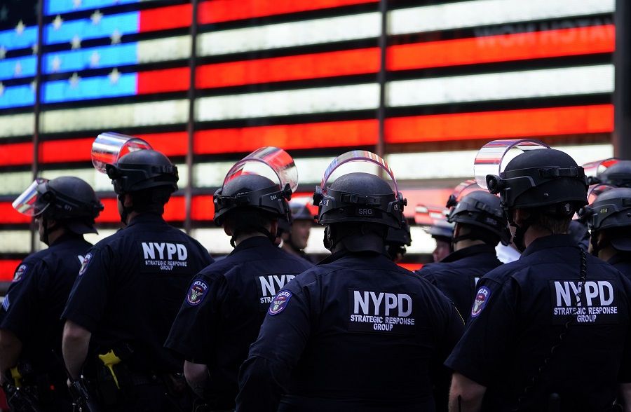 In this file photo taken on 1 June 2020, NYPD police officers watch demonstrators in Times Square during a "Black Lives Matter" protest. (Timothy A. Clary/AFP)