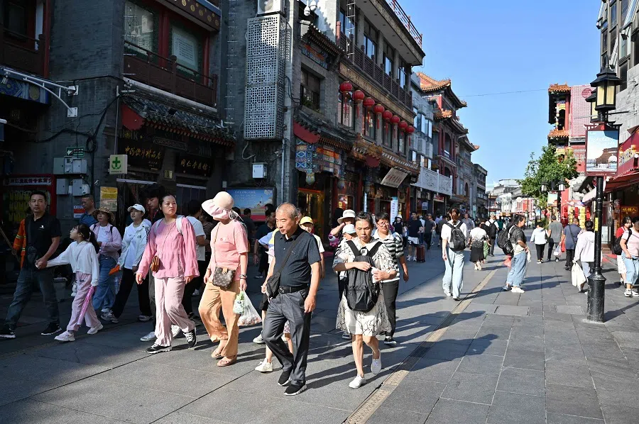People walk along the Dazhalan street in Beijing on 29 August 2024. (Adek Berry/AFP)