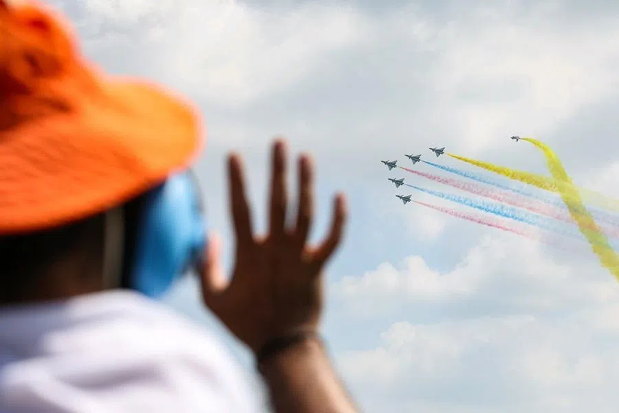 A spectator waving to the J-10 fighter jets from the People’s Liberation Army Air Force Bayi aerobatic team during the aerial display on 7 February 2026. (SPH Media)