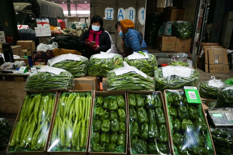 Vendors wait for customers at a market in Shenyang in China's northeastern Liaoning province on 9 December 2021. (AFP)