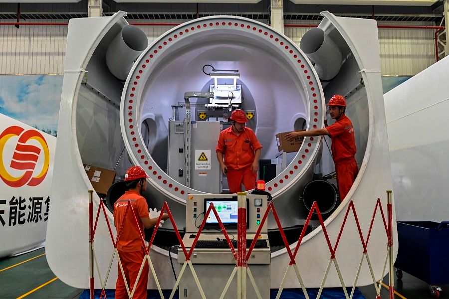 Workers are seen during the production process of wind turbines during a government-organised tour at Goldwind Technology in Yancheng, Jiangsu province, China, 14 October 2020. (Hector Retamal/AFP)