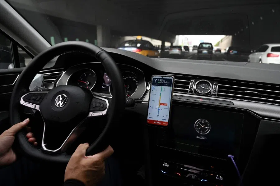 A driver uses the map on the Didi Chuxing ride-hailing app on his smartphone while driving on a street in Beijing, China, on 5 July 2021. (Greg Baker/AFP)