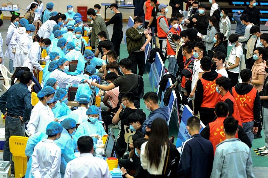 This photo taken on 30 March 2021 shows university students queuing to receive the Sinovac Covid-19 coronavirus vaccine at a university in Qingdao, Shandong province, China. (STR/AFP)