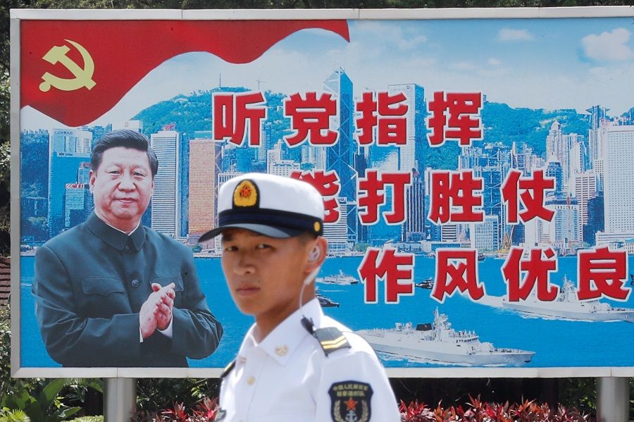 A People's Liberation Army (PLA) Navy soldier stands in front of a backdrop featuring Chinese President Xi Jinping during an open day of Stonecutters Island naval base, in Hong Kong, China, on 30 June 2019. (Tyrone Siu/File Photo/Reuters)