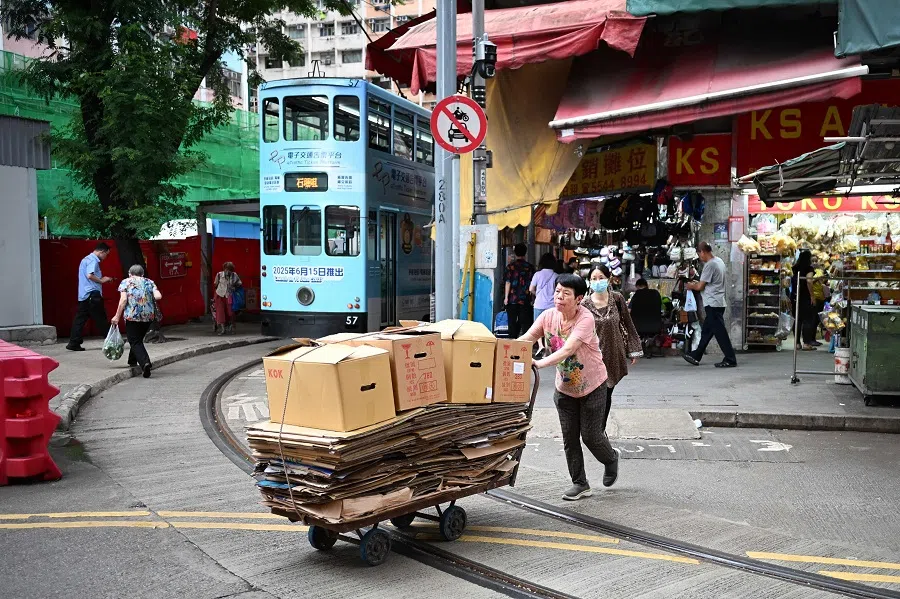A woman pushes a cart full of cardboard for recycling in Hong Kong on 16 June 2025. (Peter Parks/AFP)