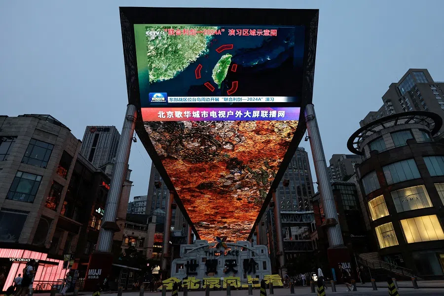 A large screen shows news footage of a map of military drills conducted by the Eastern Theatre Command of the Chinese People’s Liberation Army in five areas around the island of Taiwan, in Beijing, China, on 23 May 2024. (Tingshu Wang/Reuters)
