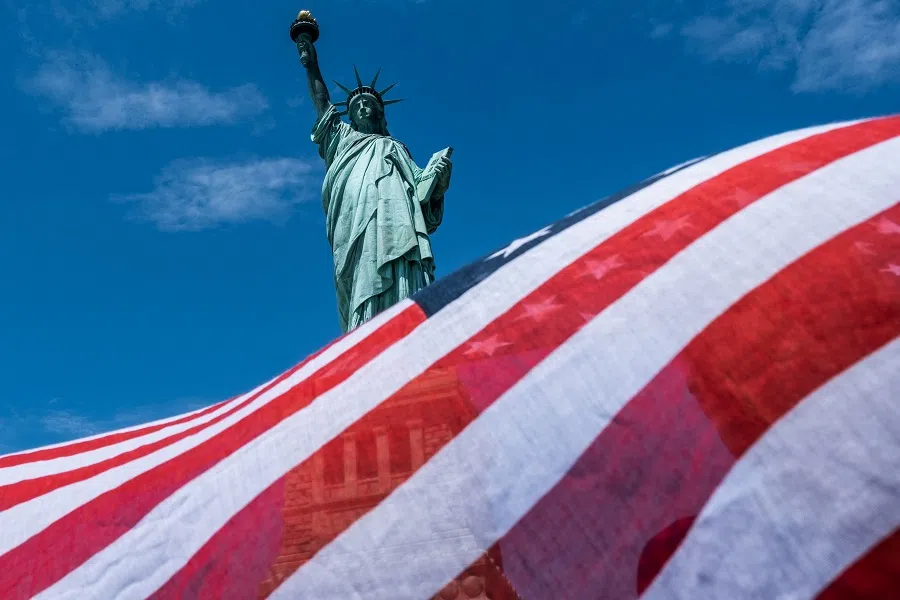 The Statue of Liberty is seen over a wind blown American flag scarf on Liberty Island on 20 July 2020 in New York City. (Jeenah Moon/Getty Images/AFP)