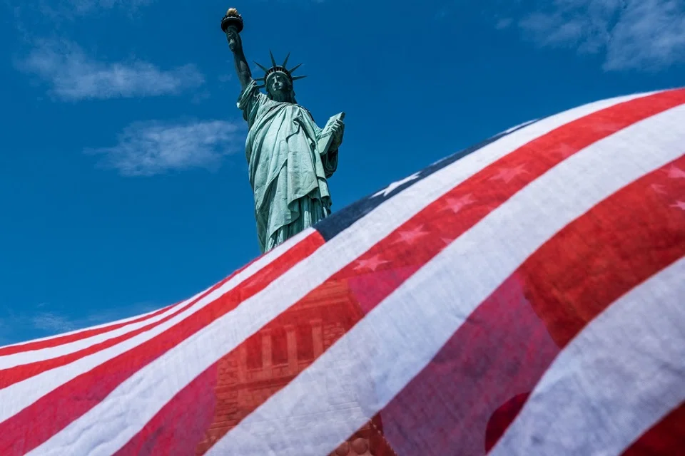 The Statue of Liberty is seen over a wind blown American flag scarf on Liberty Island on 20 July 2020 in New York City. (Jeenah Moon/Getty Images/AFP)