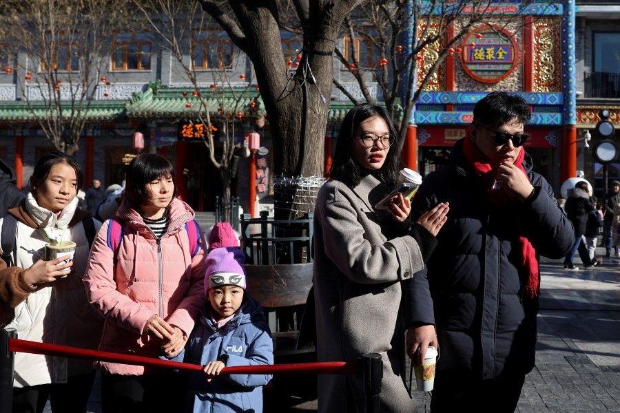 People line up outside a restaurant at Qianmen pedestrian street in Beijing, China, on 26 January 2024. (Florence Lo/Reuters)
