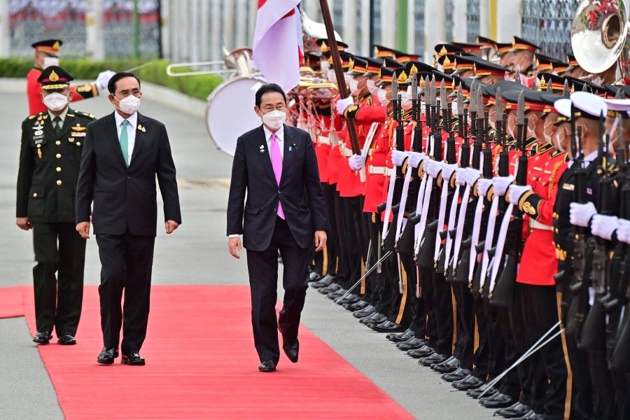 Japan's Prime Minister Fumio Kishida (centre) and Thai Prime Minister Prayut Chan-O-Cha inspect the honour guard at Government House in Bangkok on 2 May 2022. (Lillian Suwanrumpha/AFP)