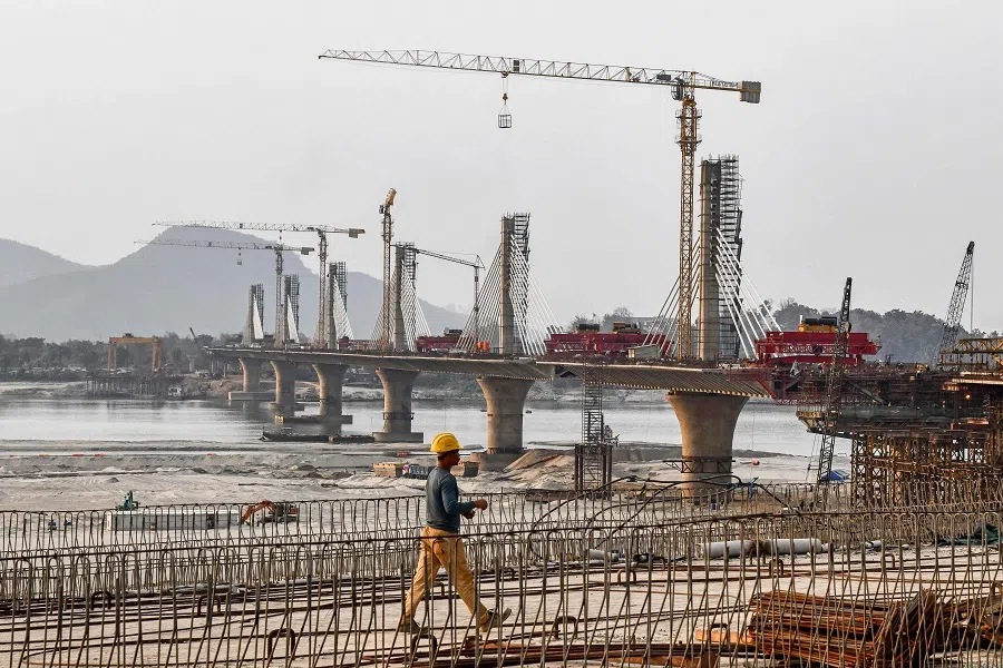 A worker walks at the site of the under-construction bridge over the Brahmaputra River in Guwahati on 27 February 2025. (Biju Boro/AFP)